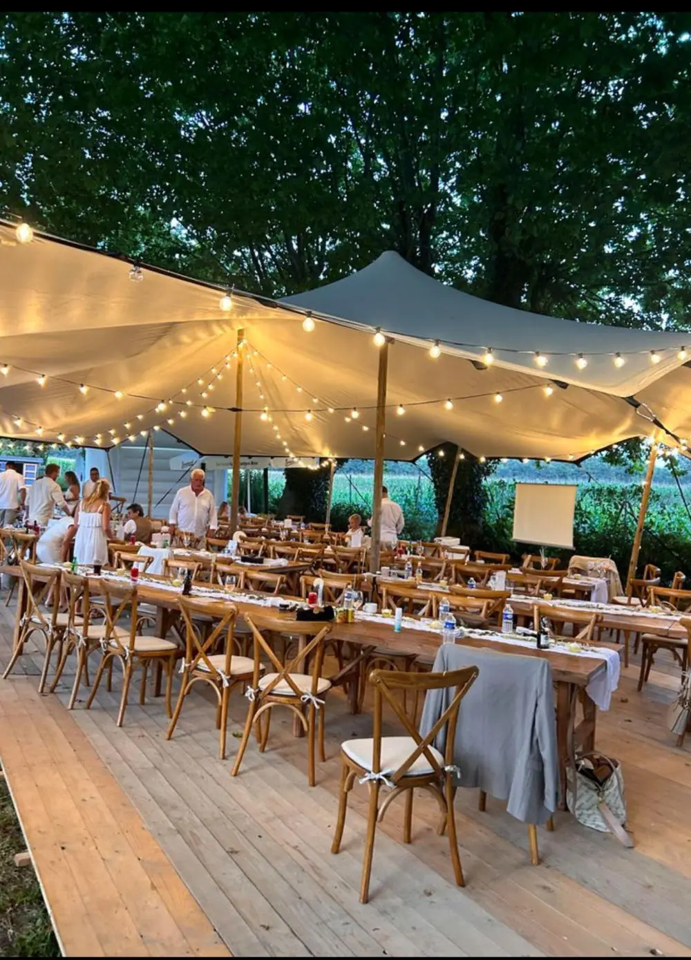 Festtafel unter beleuchtetem Stretchzelt am Abend